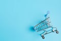 Shopaholic. Buyer. Shopping concept. Close-up. Isolated shopping trolley on a blue background. Copy space.