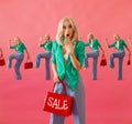 Shopaholic shocked woman holding red bag with sign sale on the pink background, shopping, sale, black friday concept Royalty Free Stock Photo