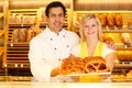 Shopkeeper and baker in Bakery present pretzels Royalty Free Stock Photo