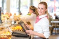 Shopkeeper at bakery working at cash register Royalty Free Stock Photo