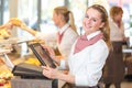 Shopkeeper at bakery working at cash register Royalty Free Stock Photo