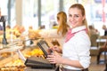 Shopkeeper at bakery working at cash register