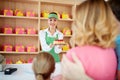 Shopkeeper gives cakes with strawberry to young family Royalty Free Stock Photo