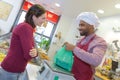 Shopkeeper gives pastry to woman Royalty Free Stock Photo