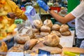 A shopkeeper interacting with customers at a bread stall in Borough Market, London