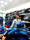 Shopkeeper putting pile of garments before costumers, Indore, MP, India