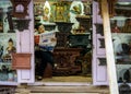 Shopkeeper reading a newspaper in her handicraft shop.