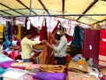 Shopkeepers folding fabrics on their cloth stall in India Royalty Free Stock Photo