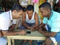 Shopkeepers playing Ludo game in mobile device in a hot summer day