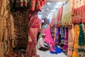 Shopkeepers selling colorful traditional saris and textiles in a shop in a market in old