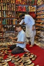 Shopkeepers tend to shoe shop selling hand made leather khussas Karachi Pakistan