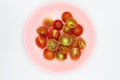 Shopped tomatoes in pink dish on white background