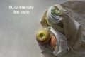 Shopper bag with collapsible silicone mug and apples in reusable fruit pouch