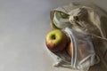 Shopper bag with collapsible silicone mug and apples in reusable fruit pouch