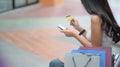 Shopper girl hold credit cards and smartphone in hand with a shopping bag placed on the side Royalty Free Stock Photo