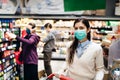 Shopper with mask safely buying for groceries due to coronavirus pandemic in grocery store.COVID-19 shopping.Quarantine