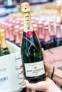 Shopper hand holding a bottle of french Moet&Chandon Imperial Brut brand Champagne