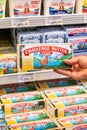 Shopper`s hand holding a box of Challenge Brand Salted Butter