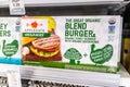 Shopper`s hand holding a package of Applegate Organics brand turkey meat Burgers blended with mushrooms