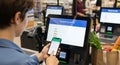Shopper Uses Mobile Pay at Self-Checkout Terminal Royalty Free Stock Photo