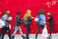 A shopper walking against red wall