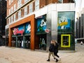 Shopper walks past Disney flagship store, Oxford Street, London