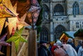 Shoppers at Exeter Christmas market. A woman looks up admiring a star shaped lantern