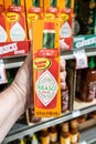 Shoppers hand holding a box containing a bottle of McIlhenny Co. Tabasco brand hot pepper sauce Royalty Free Stock Photo