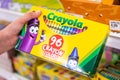 Shoppers hand holding a box of Crayola brans 96 crayon colors