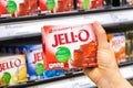 Shoppers hand holding a box of Jell-O brand strawberry gelatin dessert