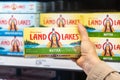 Shoppers hand holding a box of Land-o-lakes butter