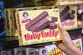 Shoppers hand holding a box of little Debbie Nutty Buddy brand crunchy wafer bars with peanut butter