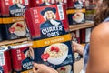 Shoppers hand holding a box of Quaker Oats 100% whole grains oats