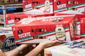 Shoppers hand holding a 18 cans box of Tecate brand mexican beer