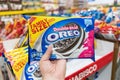 Shoppers hand holding a family size package of Oreo brand cookies