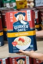 Shoppers hand holding a family size package of Quaker oats brand old fashioned oats