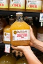 Shoppers hand holding a glass bottle of Martinelli`s brand 100% unfiltered apple juice