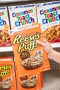 Shoppers hand holding a  package of General MIlls Reese`s Puffs brand sweet and crunchy peanut butter corn puffs cereal Royalty Free Stock Photo