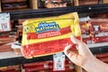 Shoppers hand holding a package of Hebrew National brand quarter pound beef franks