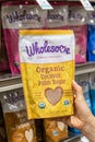 Shoppers hand holding a package of Wholesome brand Organic Coconut Palm Unrefined Brown Sugar