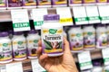 Shoppers hand holding a plastic bottle of Nature`s Way Turmeric vegetarian capsules
