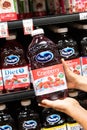 Shoppers hand holding a plastic bottle of Ocean Spray brand 100% cranberry juice cocktail