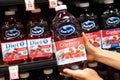 Shoppers hand holding a plastic bottle of Ocean Spray brand 100% cranberry juice cocktail