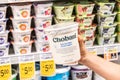 Shoppers hand holding a plastic container of Chovani brand 0% milkfat free Greek yogurt