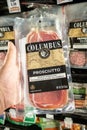 Shoppers hand holding a plastic package of Columbus brand sliced italian style cured prosciutto