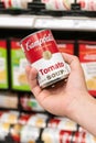 Shoppers hand holding a tin can of Campbells Brand Tomato soup Royalty Free Stock Photo