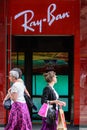 Shoppers pass by a Ray Ban store on a high street in London Royalty Free Stock Photo