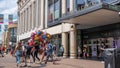 Shoppers Passing A Man Selling Novelty Childrens Balloons