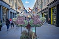 Shoppers walking under a canopy of brightly coloured butterflies in Southgate Shopping Centre in Bath, Avon, UK