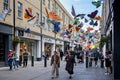 Shoppers walking under a canopy of brightly coloured butterflies in Southgate Shopping Centre in Bath, Avon, UK